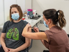 Respiratory therapist  Karen Schmid receives the Pfizer Covid-19 vaccine from registered nurse Lianne Korte, becoming the first person in Saskatoon to receive the vaccine. Photo taken in Saskatoon, SK on Tuesday, December 22, 2020.