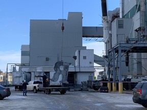 A crane lowers part of the Robin Hood flour sign from the Ardent Mills plant on 33rd Street East into a truck. The sign, which has stood on top of the building since 1927, is to be refurbished. (Photo courtesy of Prairie Crane)