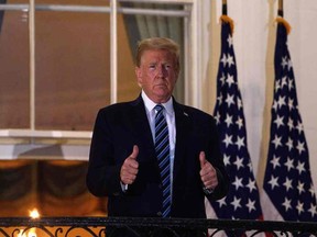 U.S. President Donald Trump gives two thumbs up from the Truman Balcony upon his return to the White House from Walter Reed Medical Center, where he underwent treatment for Covid-19, in Washington, DC.