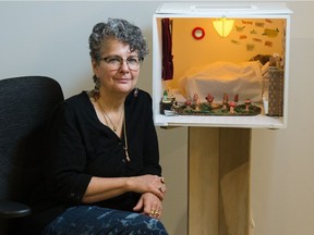 Sylvia Ziemann sits next to her miniature installation entitled "Path to Individuation" at the Dunlop Art Gallery Central location in Regina on Jan. 30, 2021. The piece is part of the current exhibition, States of Collapse.