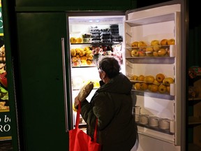 A woman grabs recently placed food from a community refrigerator in Brooklyn, New York City.  An idea for a similar community fridge and pantry is taking shape in Saskatoon's Riversdale neighbourhood.