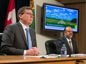 Saskatchewan Premier Scott Moe, left, communicates the government's plan to reopen the province's economy at a news conference held at the Saskatchewan Legislative Building in Regina, Saskatchewan on April 23, 2020. On right is Saskatchewan's chief medical health officer Dr. Saqib Shahab.