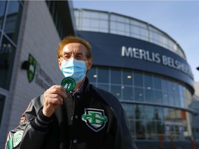 Merlis Belsher holds up his proof of vaccination sticker outside of Merlis Belsher Place after getting his COVID-19 immunization. Photo taken in Saskatoon on Friday, March 12, 2021.