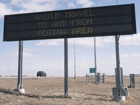 A car travels eastbound from Regina while a government sign tells people to avoid the city and area. MICHAEL BELL / Regina Leader-Post