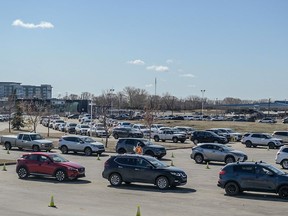 Hundreds of people line up to receive their COVID-19 vaccine at the Praireland Park drive-thru clinic.