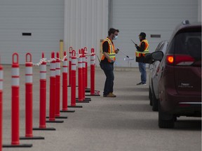 Health-care workers wait outside for patients at a drive-thru testing site for Covid-19 in Saskatoon, Saturday, September, 12, 2020.