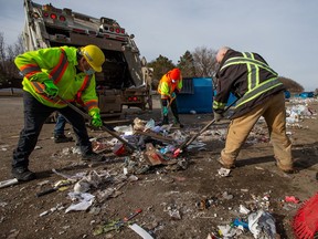 City workers and a crew from Urban Camp help to clean up the garbage around the Meadowgreen recycling depot on March 26, 2021.