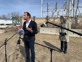 Saskatchewan NDP Leader Ryan Meili speaks about his party's plan to increase the number of renewable energy jobs in the province at a news conference in Saskatoon's Riversdale neighbourhood on Thursday, April 1, 2021. NDP energy and resources critic Erika Ritchie stands behind Meili. (Phil Tank/Saskatoon StarPhoenix)