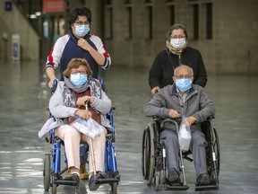 José Eduardo Gomez helps his mother Gloria Osorio wheel his grandparents Amada and José Osorio to their appointments at the Covid-19 vaccination centre at the Olympic Stadium in Montreal Monday April 5, 2021.