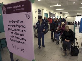 People line up to get immunized against H1N1 on Nov. 25, 2009 at Prairieland Park in Saskatoon, Sask.