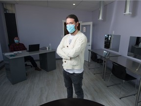 Michael Parker, executive director of the Newo Yotina Friendship Centre, stands in the centre's new safe consumption area in Regina, Saskatchewan on May 7, 2021. The tables on frame right are to be stations for consumption, equipped with exhaust vents overhead. Seen on frame left is primary care paramedic Emile Gariepy, who will be on site when the facility opens for clients.