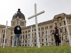 Ret Brailsford, left, spokesperson for Regina Harm Reduction Coalition, and Rebecca Granovsky-Larsen stand amongst the crosses on the front lawn of the legislative Building in Regina on Saturday, May 8, 2021. The crosses honour people who have died from drug overdoses and to call for more action on harm reduction from the provincial government.