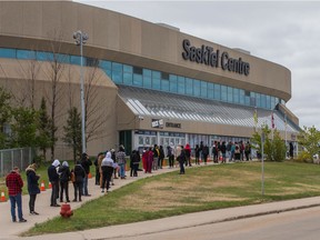 A line of people wait to receive their dose of COVID-19 vaccine at the clinic run by the Saskatoon Tribal Council at SaskTel Centre.
