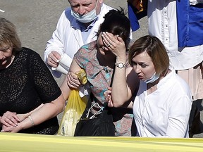 A woman cries as she is taken to an ambulance at the scene of a shooting at School No. 175 in Kazan, the capital of Russia's republic of Tatarstan, on May 11, 2021.