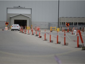 A single vehicle passes through the empty queue at Regina's Evraz Place drive-thru vaccine clinic on June 8, 2021.