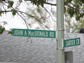 A sign post showing the corner of John A. Macdonald Road and Cartier Crescent in Saskatoon.