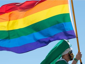 A person waves a flag from a float during the annual Queen City Pride Parade in Regina, Saskatchewan on June 12, 2021. Saskatoon's parade will be virtual this year. BRANDON HARDER/ Regina Leader-Post