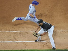 Riley Adams of the Toronto Blue Jays is safe at first base after a wild pitch as Jose Abreu of the Chicago White Sox awaits the throw in the 8th inning at Guaranteed Rate Field on June 9, 2021 in Chicago.
