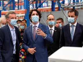 Prime Minister Justin Trudeau looks up during a tour of pharmaceutical company Pfizer with Belgian counterpart Alexander De Croo (right) in Puurs, Belgium, Tuesday, June 15, 2021.
