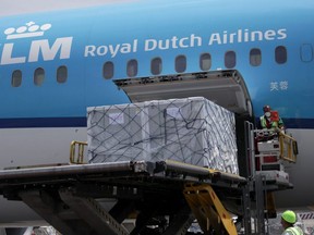 Workers unload a batch of AstraZeneca vaccines, delivered under the COVAX scheme, from a KLM Boeing 787 at Benito Juarez International Airport in Mexico City, May 27, 2021.