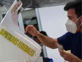 A man casts his vote at a polling station, in Mexico City, on June 6, 2021. Mexicans began voting Sunday in elections seen as pivotal to President Andres Manuel Lopez Obrador's promised "transformation" of a country shaken by the coronavirus pandemic, a deep recession and drug-related violence.