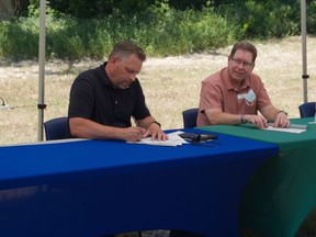 Battleford Mayor Ames Leslie (left) and North Battleford Mayor David Gillan sign an agreement to join the Coalition of Inclusive Municipalities (CIM), a network of communities aiming to fight racism. Photo provided by City of North Battleford on Wednesday, June 30, 2021. (Saskatoon StarPhoenix)
