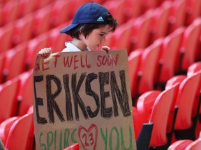 Soccer Football - Euro 2020 - Group D - England v Croatia - Wembley Stadium, London, Britain - June 13, 2021 A fan holds a banner of support for Denmark's Christian Eriksen after he collapsed on the pitch during his side's Euro 2020 match with Finland Pool via REUTERS/Catherine Ivill