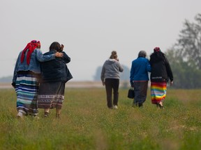 Community members walk across the field where they are searching for potential unmarked graves near the Delmas Indian Residential School site. Photo taken in Delmas, Sask. on Saturday, July 17, 2021. (Saskatoon StarPhoenix / Michelle Berg)