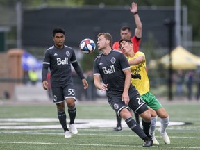 Brendan McDonough with Vancouver Whitecaps U-23 heads the ball away from Nikolas Baikas of the SK Selects all-star squad during a SK Summer Series friendly soccer match in Saskatoon in the summer of 2019.