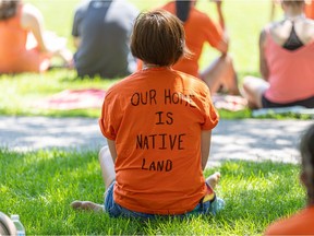 A shirt reads "Our Home is Native Land" at Kiwanis Park during the Bring Them Home event, which is a time for mourning and reflection for the residential school children instead of regular Canada Day celebrations.