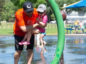 REGINA, SASK : July 2, 2021  -- Nathan Cole and his two-year-old daughter Sylvie Cole enjoy the spray pad at the South Leisure Centre in Regina, Saskatchewan on July 2, 2021. Temperatures hovered at around 35 degrees, Friday, but were expected to cool somewhat by Monday, according to Environment Canada.

BRANDON HARDER/ Regina Leader-Post