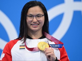 Gold medallist Canada's Maggie Mac Neil poses with her medal on the podium after the final of the women's 100-metre butterfly swimming event during the Tokyo 2020 Olympic Games at the Tokyo Aquatics Centre in Tokyo on July 26, 2021.