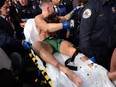 Conor McGregor is carried off a stretcher following an injury suffered against Dustin Poirier during UFC 264 at T-Mobile Arena in Las Vegas, July 10, 2021.