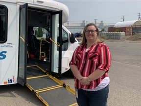 Tracey Davis, Access Transit Manager, stands in front of one of the fleet's new low-floor buses. PHOTO BY: Jillian Smith
