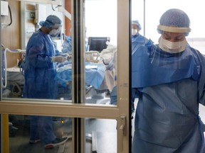 Nurse Angela Bedard stands in a doorway after helping to intubate a patient suffering from COVID-19 at Humber River Hospital, on April 28, 2021.