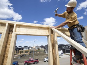 Orry Cherneski, of OJS Home Solutions, hammers nails on the roof of a new home build in the neighbourhood of Aspen Ridge in Saskatoon in this file photo from June 5, 2018. (Saskatoon StarPhoenix/Liam Richards)