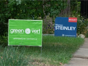 Campaign signs for the Green Party of Canada and the Regina-Lewvan Conservative candidate Warren Steinley are seen on the lawns of adjacent homes in Regina, Saskatchewan on August 19, 2021.