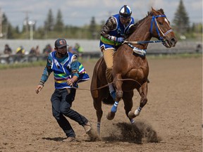 Colten Poitras (left) helps Bubba Poitras with his start during the Indian Relay Races home-opener at the historic Marquis Downs. Photo taken in Saskatoon on May 30.