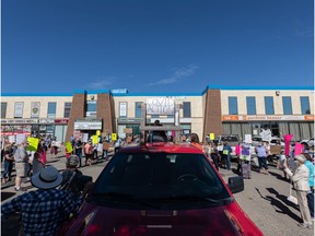About 100 people rallied in front of Health Minister Paul Merriman's office on Eighth Street in Saskatoon, urging the Saskatchewan government to implement restrictions to limit the fourth wave of the COVID-19 pandemic.