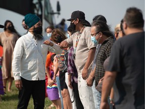 Federal NDP party leader Jagmeet Singh greets people as he arrives for a campaign stop at the Regina Indian Industrial School Cemetery in Regina, Saskatchewan on Sept. 18, 2021.