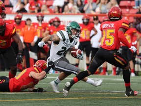 The University of Calgary Dinos try to snag University of Saskatchewan Huskies running back Adam Machart in the season opener at McMahon Stadium on Saturday.