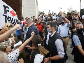 Liberal Leader Justin Trudeau encountered angry demonstrators like these ones that swarmed his a bus in Nobleton, Ont., in August.