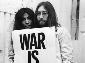 John Lennon and Yoko Ono pose on the steps of the Apple building in London, holding one of the posters that they distributed to the world's major cities as part of a peace campaign protesting against the Vietnam War.