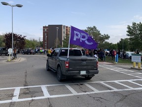 A truck with a People's Party of Canada flag drives past more than 200 people gathered near the east entrance to Saskatoon's City Hospital on Wednesday, Sept. 1, 2021 to protest mandatory proof of COVID-19 vaccination for front-line health-care workers. (Phil Tank/Saskatoon StarPhoenix)