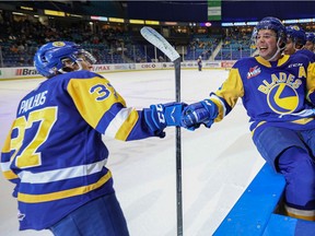 Saskatoon Blades' Josh Paulhus celebrates his goal with Kyle Crnkovic and other teammates on the bench during first-period action of the home opener game against Moose Jaw Warriors at SaskTel Centre. Photo taken in Saskatoon on Saturday, October 2, 2021.
