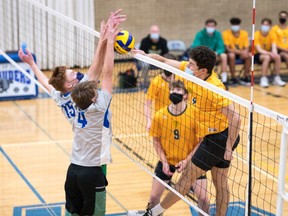 Ben Schoenfeld #4 at far right of the Aden Bowman Bears goes for the kill with teammate Nathan Bartsch #9 looking on. Putting up the block for the Walter Murray Marauders are Jeremy Tratch #4 and Adam Martens-Koop. Photo taken September 19,2021 by Victor Pankratz.