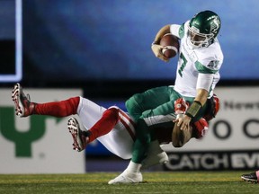 Saskatchewan Roughriders quarterback Cody Fajardo, right, is sacked by the Calgary Stampeders' Folarin Orimolade during Saturday's CFL game at McMahon Stadium. Fajardo was sacked four times during the game, won 20-17 by Saskatchewan.