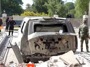 A destroyed vehicle is parked in front of Iraqi Prime Minister Mustafa al-Kadhimi's residence following an assassination attempt by an armed drone in Baghdad, Iraq.