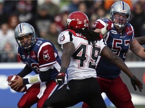 Scott Flory (57) slides over to block Calgary Stampeders Malik Jackson while protecting quarterback Anthony Calvillo during a CFL game in 2009.