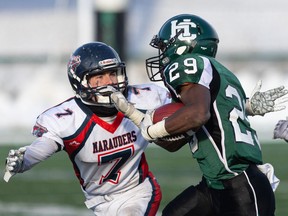 Charles Sawi of Saskatoon Holy Cross runs the football as Regina Miller's Kenton Appel defends during the provincial high-school football final at SMF Field.